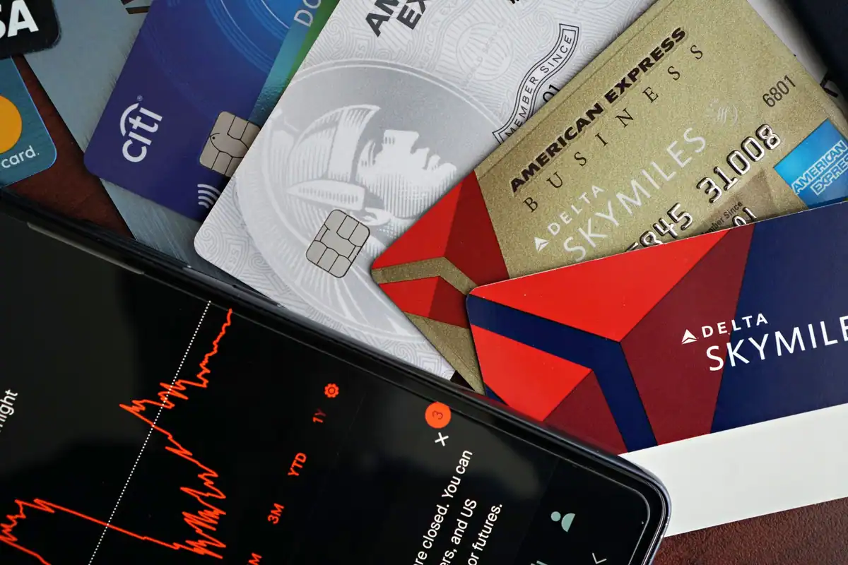 Carduri bancare și un grafic financiar pe ecranul unui telefon