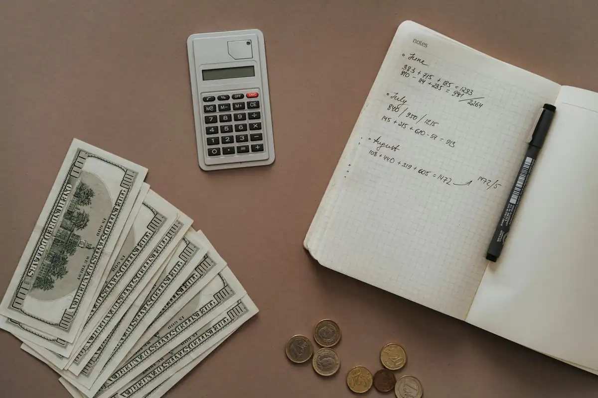 Calculator, carnet și bancnote pe masă, pentru calculul costurilor