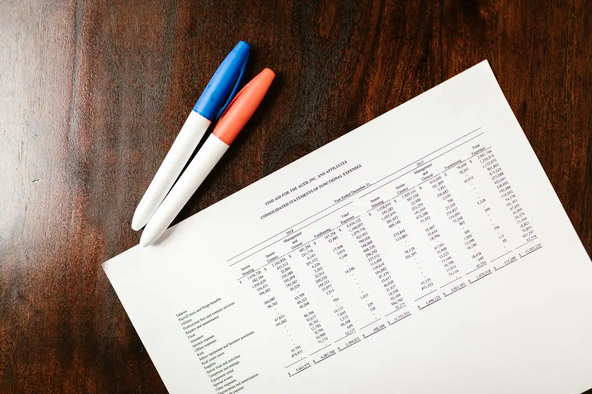 Extras financiar pe birou, cu pixuri colorate pentru verificare