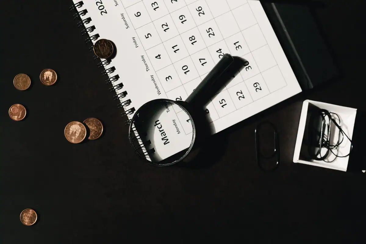 Calendar, lupă și monede, imagine a termenului unui depozit