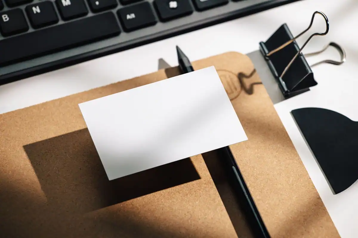 Card alb, tastatură și clamă pe un birou minimalist, pregătite pentru deschiderea contului