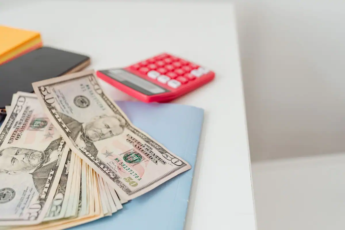 Carnete, bancnote și calculator pe birou, pentru calculul dobânzii