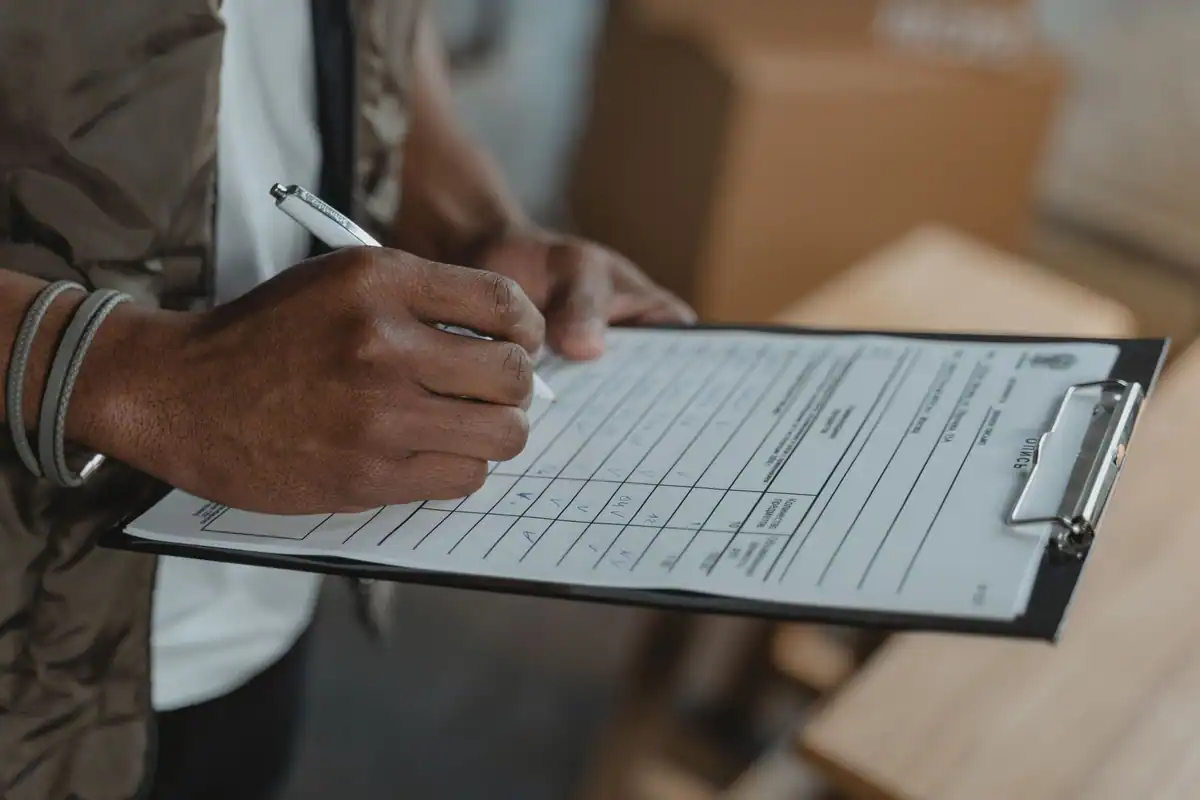 Persoană care completează un formular prins pe un clipboard
