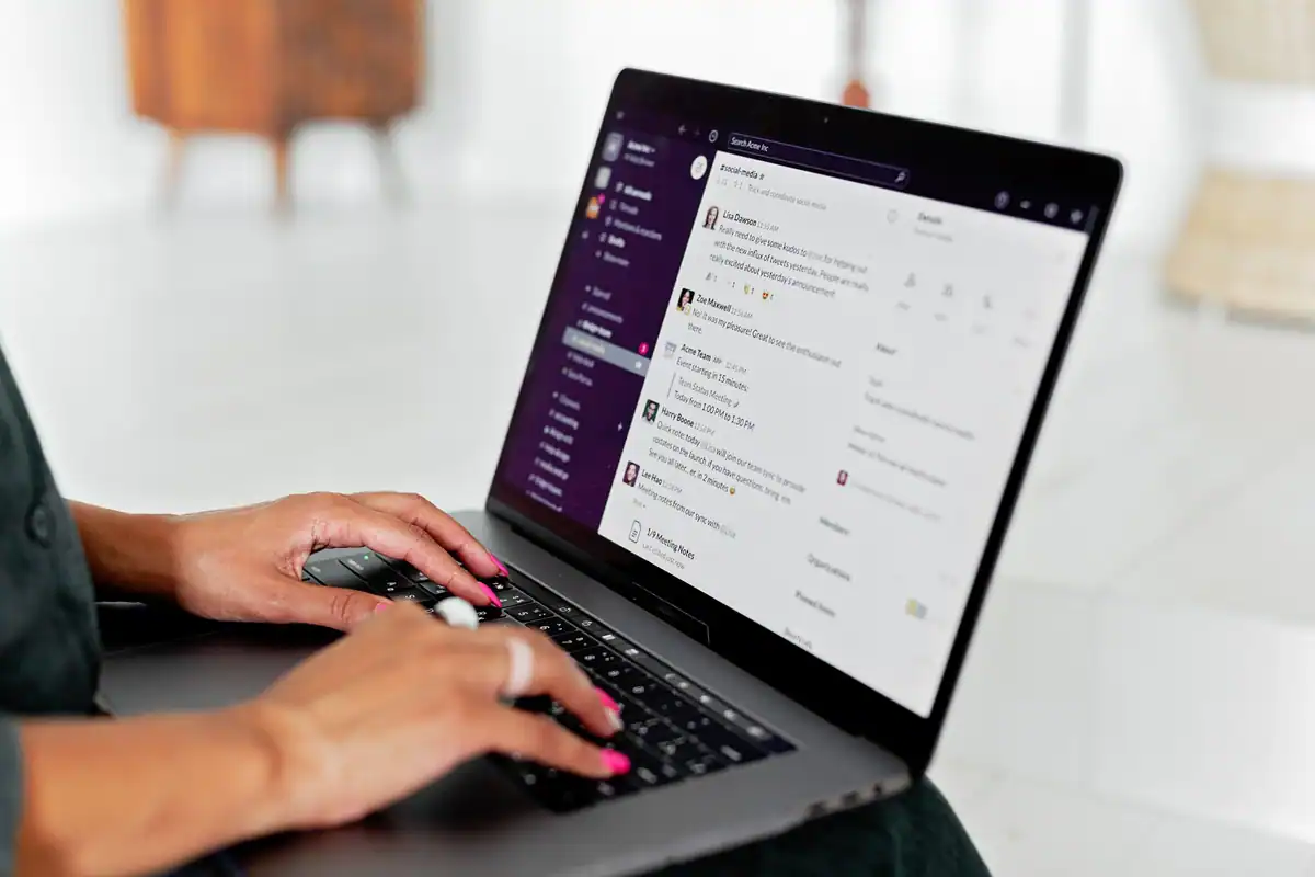 Femeie care scrie mesaje pe laptop într-un birou modern